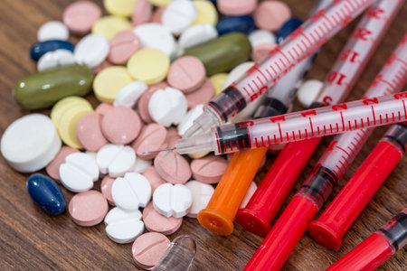 pills with insulin syringe on a tableの写真素材