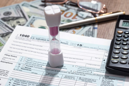hourglass with tax form, money and calculator