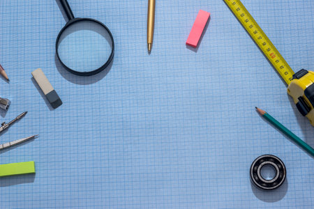 pencil, compass and rulers on graph paper background