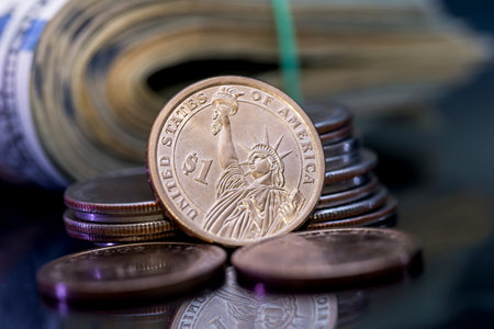 us roll dollar with coin isolated on black.の写真素材