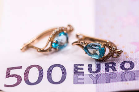gold earrings lying on euros banknote.の写真素材