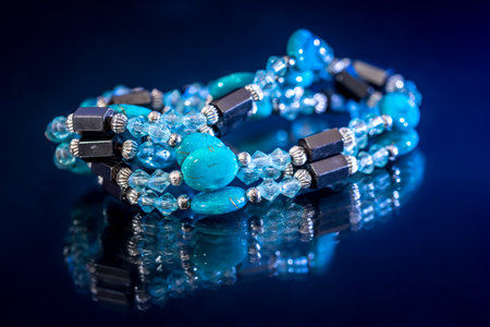 bracelet mix precious stones and beads isolated on dark blue.の写真素材
