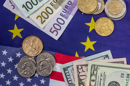 euor and dollar bills with coin on flags.