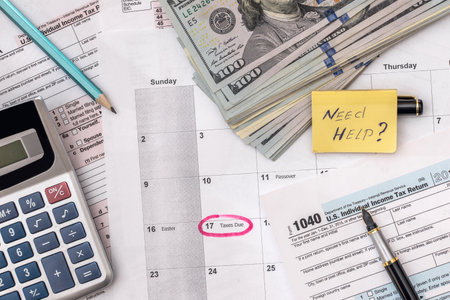 tax form with pen, calendar, money on deskの写真素材