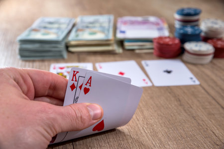 man holding play card. poker chips, us dollar.の写真素材