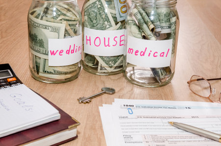 Tax forms 1040 with pen, calculator and dollar in jar glassの写真素材