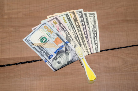 Different dollar bills dry on a cordの写真素材