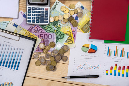 Business report with euro coin and banknotes