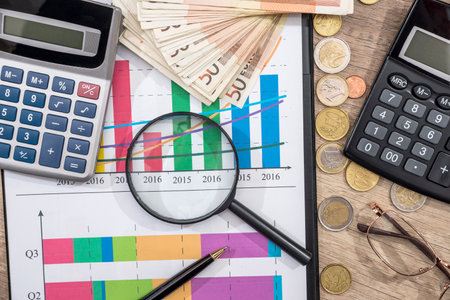 Finance concepts - business graph, euro money, pen, magnifying glasses, calculator