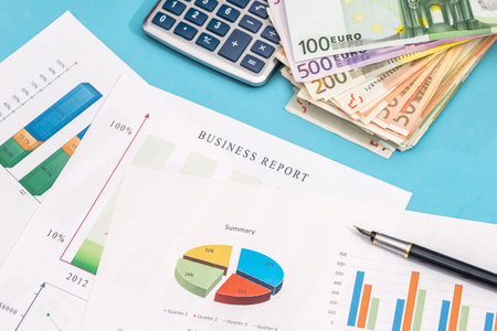 business graph with euro banknote and calculator on blue backgroundの写真素材