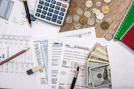 Financial statistics documents - tax form, personal budget with money, pen, calculatorの写真素材