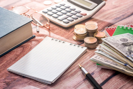 Home savings - notepad, dollars on desk.の写真素材