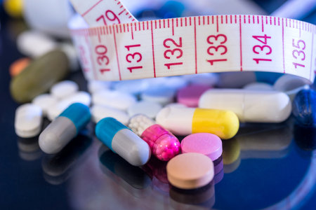 medical pills, vitamin tablets with measuring tape isolated on black background.の写真素材