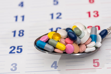 Colorful pills on plate on a calendar medication.の写真素材