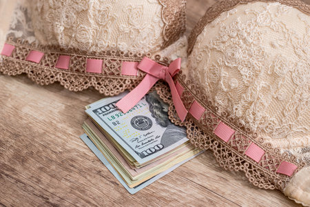 beige bra and dollars on woodenの写真素材