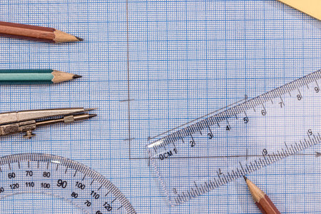 Measuring tools above blue graph paper.