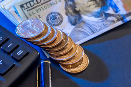 US dollars, coin, calculator and pen.