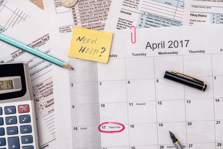 tax form with pen, calendar, money on deskの写真素材