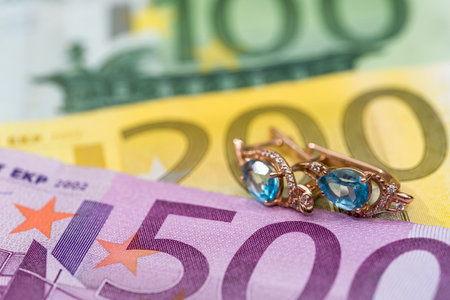 gold earrings lying on euros banknote.の写真素材