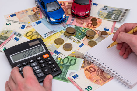 two cars with euro bills, notepad and penの写真素材