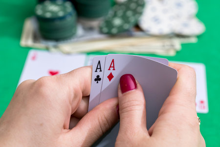 two aces in hand with poker card, chips and moneyの写真素材