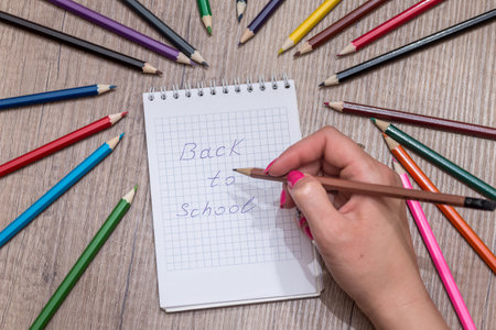 Girl writes the text "back to school" colored pencilsの写真素材