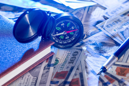 compass on usa hundred dollars with note, pen. journey concept.