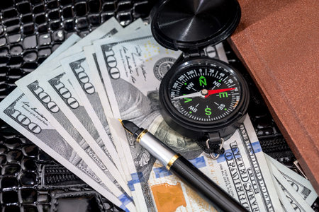 compass on usa hundred dollars with note, pen. journey concept.の写真素材