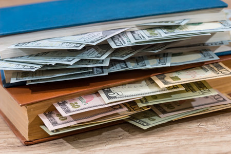 us 100 dollar in book on desk.