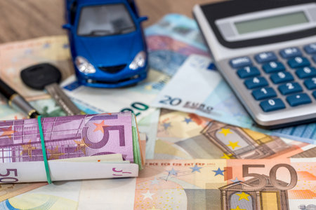 blue toy car with euro banknotes, calculator and pen.の写真素材