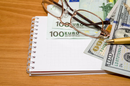 financial concept - money, empty notepad with penの写真素材
