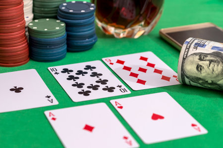 casino chips for gambling, cognac and playing cards, money and phone on green