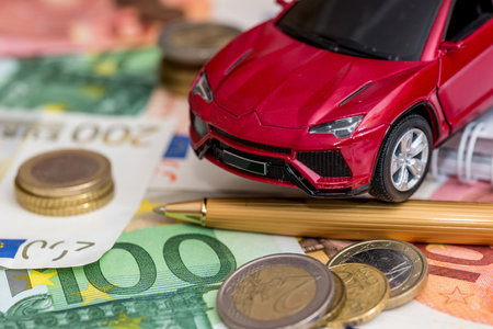 luxury toy car on Euro cash with calculator and penの写真素材