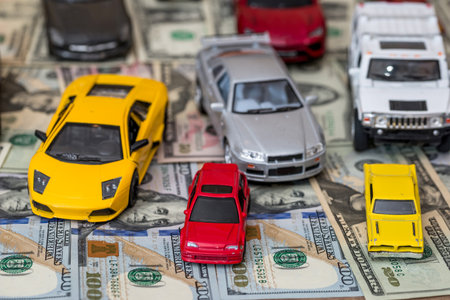 many toy cars on dollar backgroundの写真素材