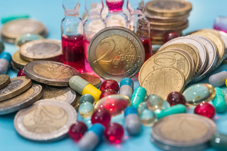 Euro coin with pills isolated on blue backgroundの写真素材