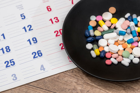 Colorful pills on plate on a calendar medication.の写真素材