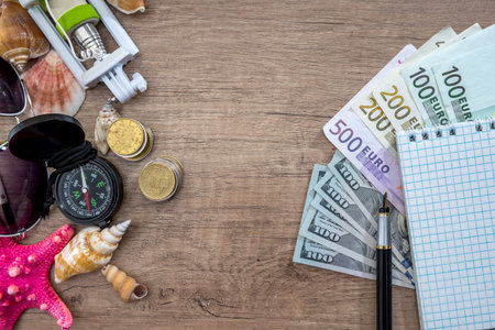 Adventure concept - traveler items with money on desk.の写真素材