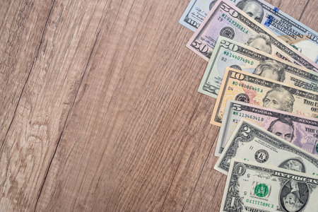 set of American dollars on a wooden desk