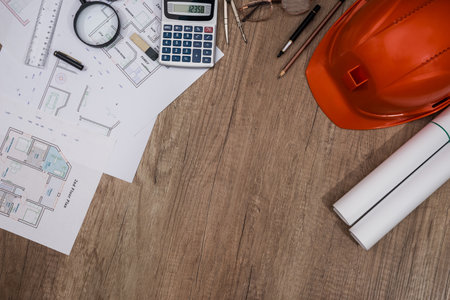 Construction concept - architectural project, blueprints, helmet, measuring tapeの写真素材