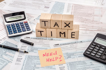 tax form with wooden cubes, sticker, pen and calculatorの写真素材