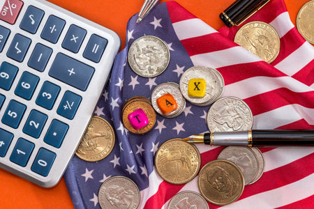 wooden cubes tax with flag, dollar, coin and calculator on orange background
