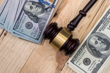 Money and judges hammer on wooden tableの写真素材