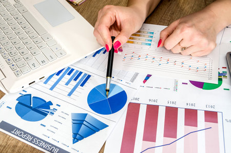 A person works with charts and a computer