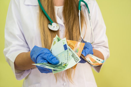 Doctor hold euro money isolated on green