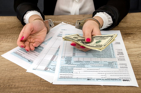 tax form, hands in handcuffs, moneyの写真素材
