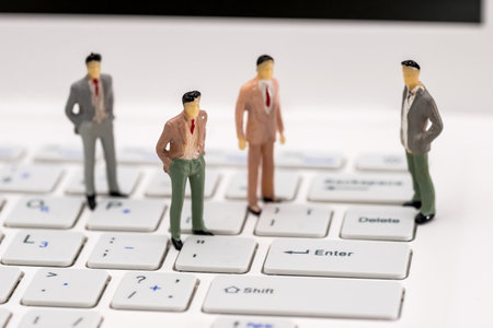 Small toy people are on the laptop, close upの写真素材