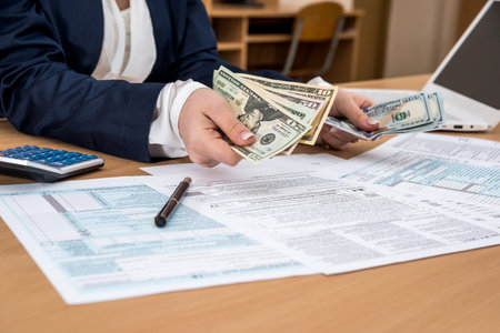 Business lady counts dollars, over the tax form 1040