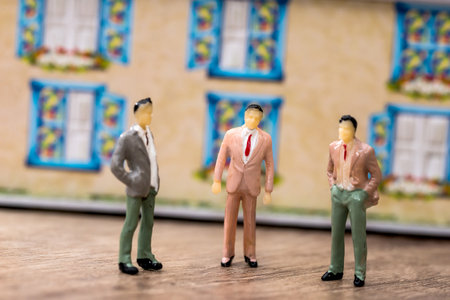 small toy people stand opposite the toy houseの写真素材