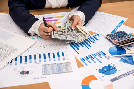 Business lady counts dollars and checks the graphics