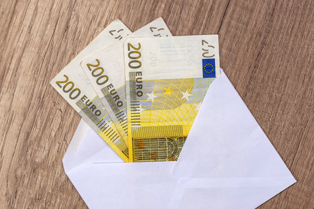 Open an envelope with euro banknotes on the table